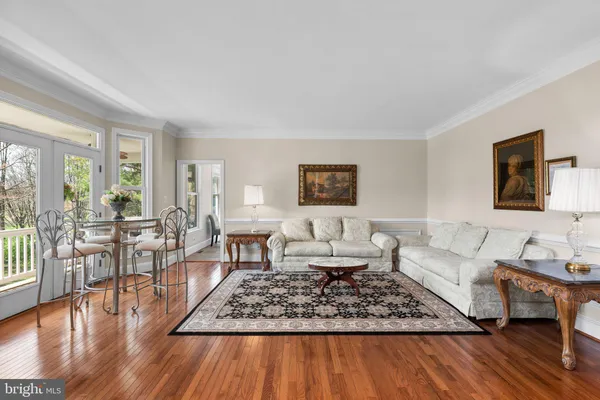 a kitchen with stainless steel appliances granite countertop a stove a refrigerator a kitchen island a dining table and chairs with wooden floor