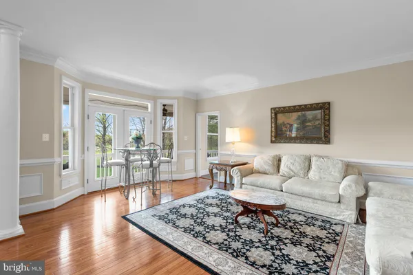 a kitchen with stainless steel appliances granite countertop a stove a sink dishwasher a dining table and chairs with wooden floor