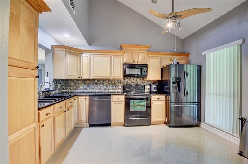 9316 Ketay Circle Boca Raton, FL 33428 - Photo 8 of 30 a kitchen with stainless steel appliances granite countertop a refrigerator a stove top oven a sink and cabinets