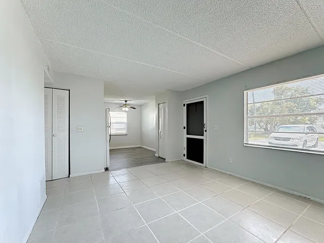 an empty room with windows and closet