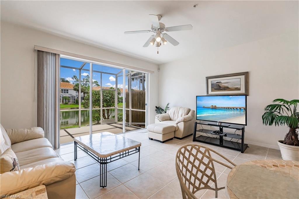15451 Marcello Circle, Unit 229 Naples, FL 34110 - Photo 11 of 30 a living room with furniture ceiling fan and a rug