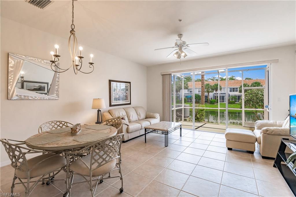 15451 Marcello Circle, Unit 229 Naples, FL 34110 - Photo 12 of 30 a living room with furniture and a floor to ceiling window