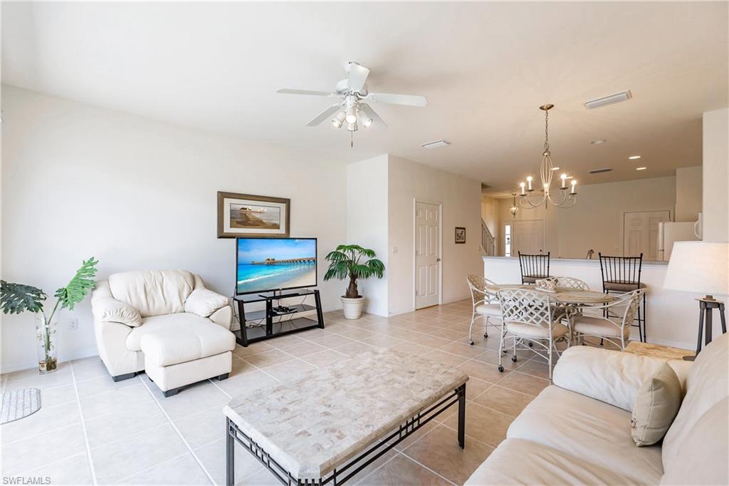 15451 Marcello Circle, Unit 229 Naples, FL 34110 - Photo 13 of 30 a living room with furniture and a chandelier