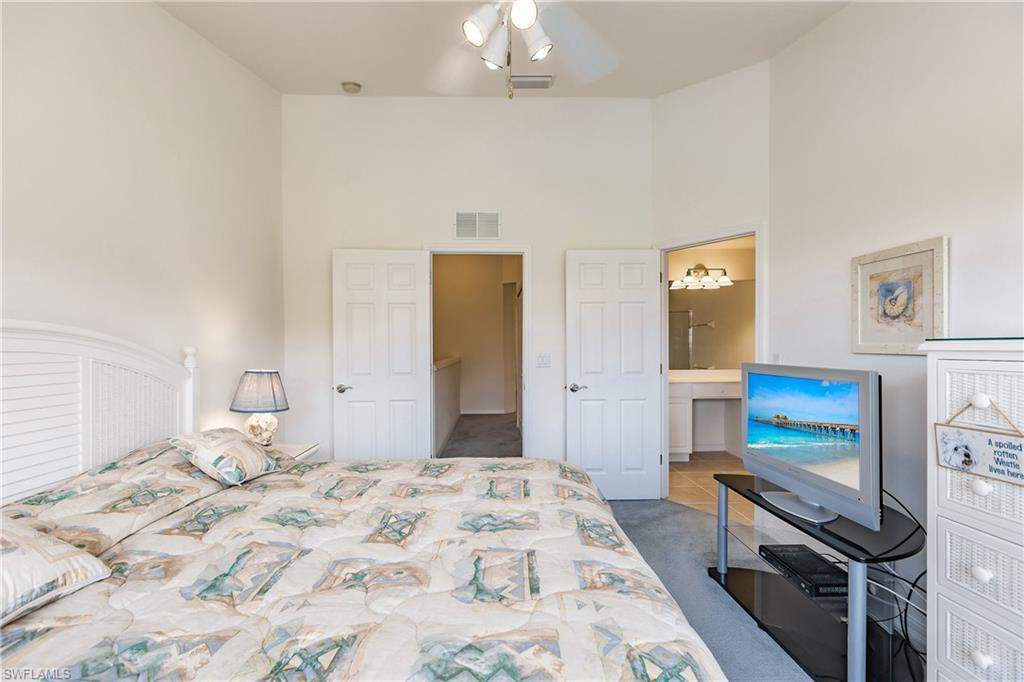 15451 Marcello Circle, Unit 229 Naples, FL 34110 - Photo 18 of 30 a bedroom with a bed and a view of bedroom