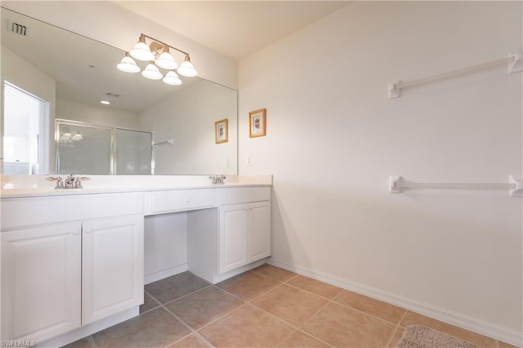 15451 Marcello Circle, Unit 229 Naples, FL 34110 - Photo 19 of 30 a bathroom with a sink a mirror and a light fixture