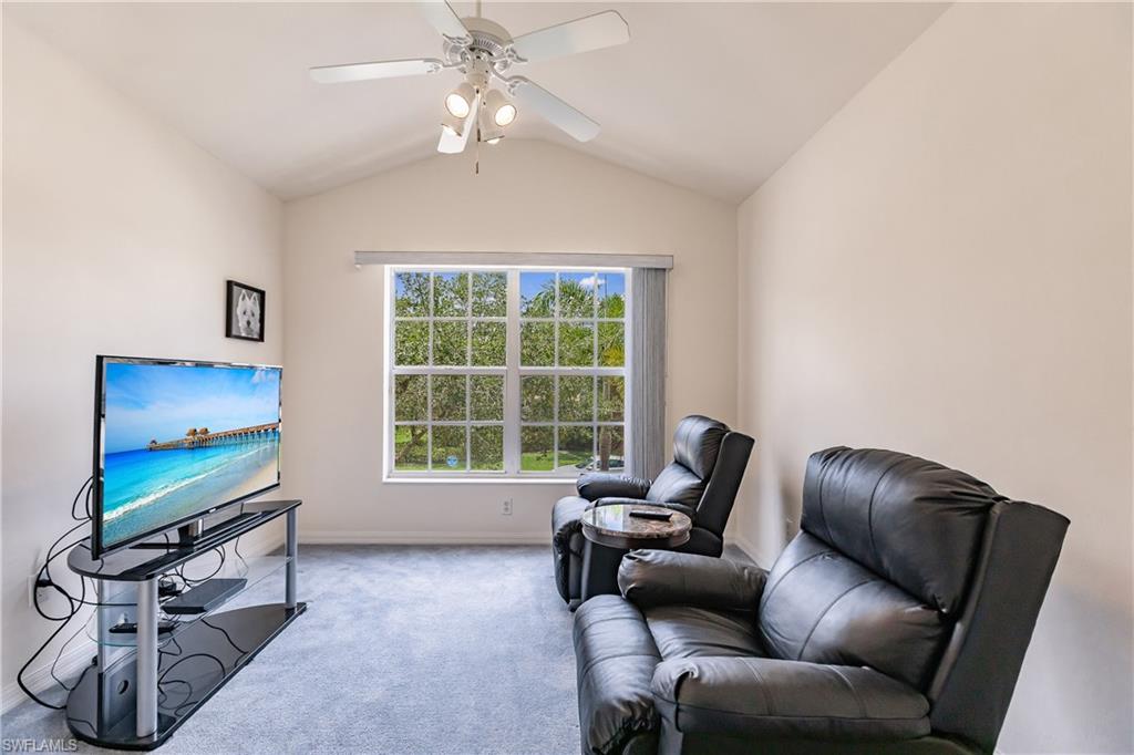 15451 Marcello Circle, Unit 229 Naples, FL 34110 - Photo 23 of 30 a living room with furniture a flat screen tv and a window