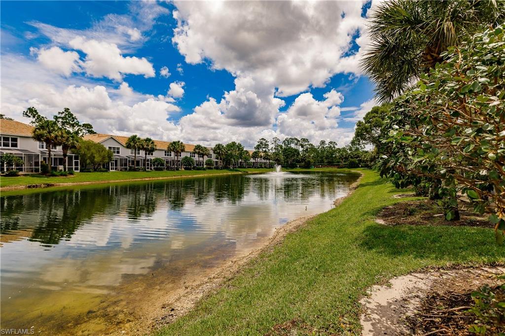 15451 Marcello Circle, Unit 229 Naples, FL 34110 - Photo 27 of 30 a view of a lake with houses in the background