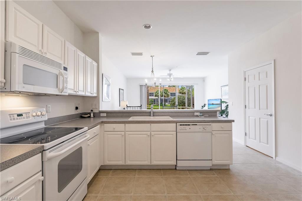 15451 Marcello Circle, Unit 229 Naples, FL 34110 - Photo 7 of 30 a kitchen with a sink stove and cabinets