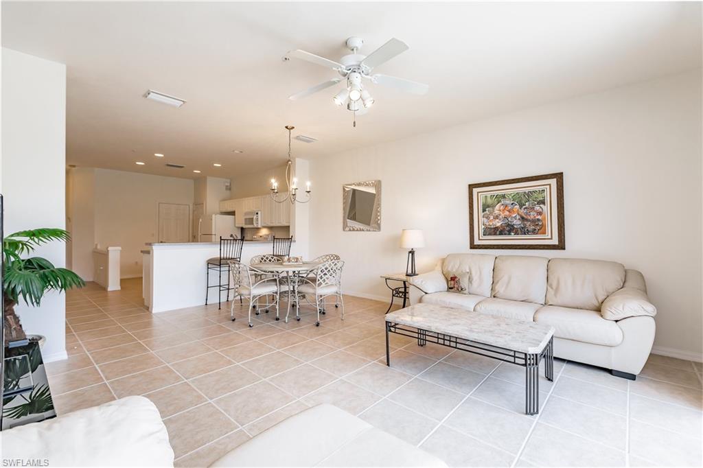15451 Marcello Circle, Unit 229 Naples, FL 34110 - Photo 10 of 30 a living room with furniture and a chandelier