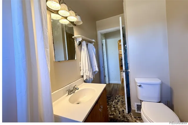 a bathroom with a sink a toilet a mirror and vanity
