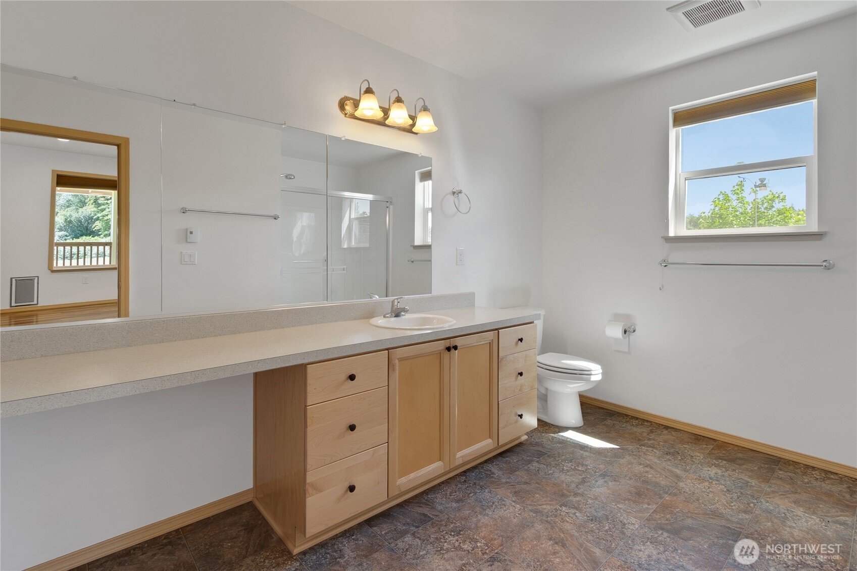 1450 Southeast Spruce Road Port Orchard, WA 98367 - Photo 23 of 39 a spacious bathroom with a double vanity sink a toilet and a window