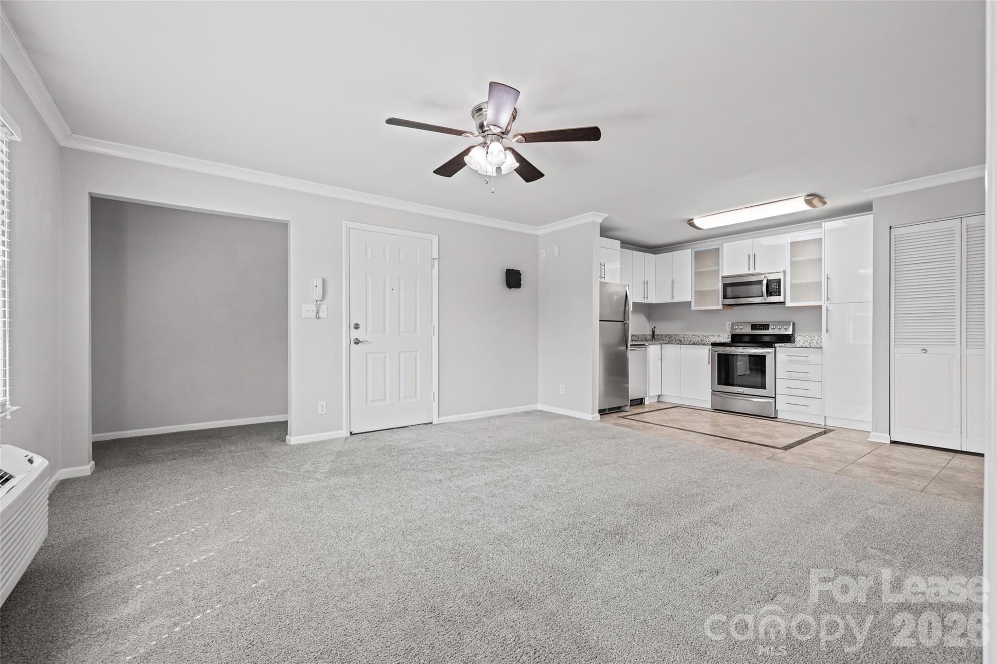 113 Stroupe Road, Unit E Gastonia, NC 28056 - Photo 7 of 33 a view of a kitchen with refrigerator and a ceiling fan