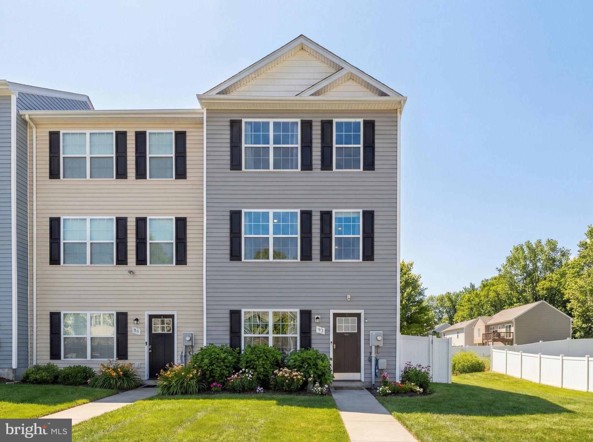 a front view of a house with garden and trees