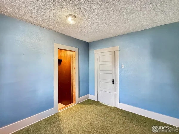 an empty room with closet and mirror