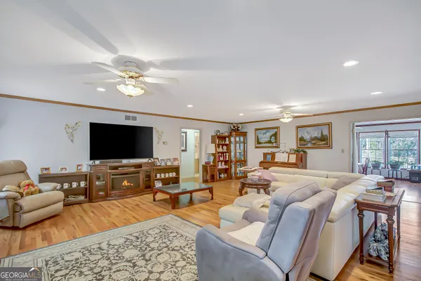 a living room with furniture flat screen tv and wooden floor