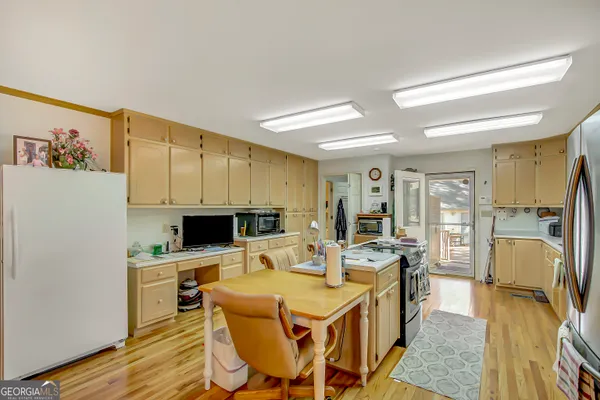 a large kitchen with a table chairs refrigerator and cabinets