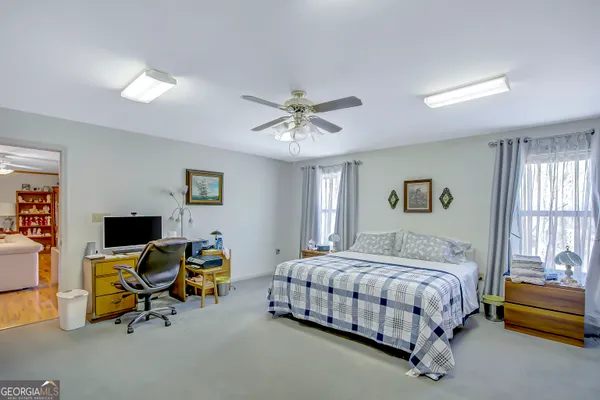 a bedroom with a bed a couch and a chandelier