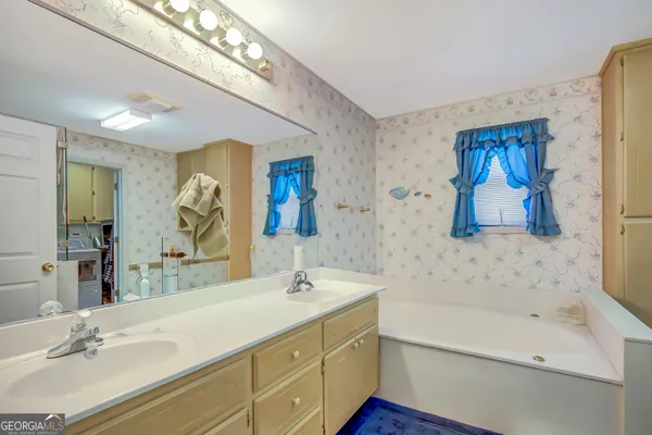 a bathroom with a tub sink and mirror