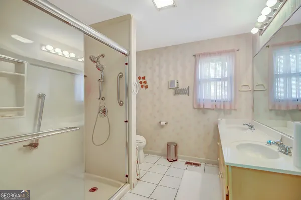 a bathroom with a sink a toilet and shower