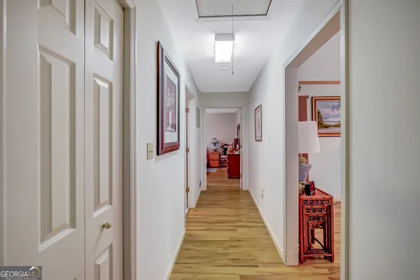 a hallway with wooden floor and stairs