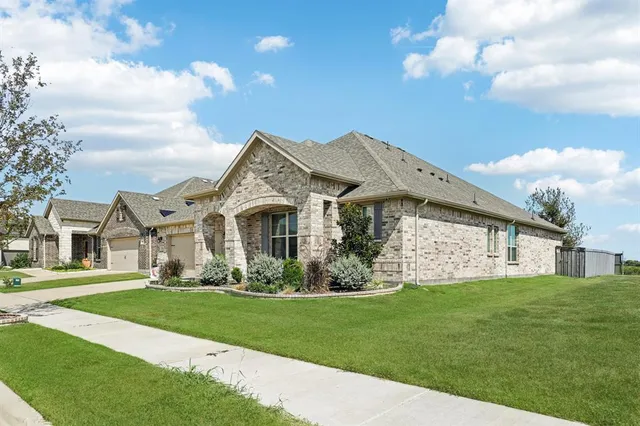 a front view of a house with a garden and trees