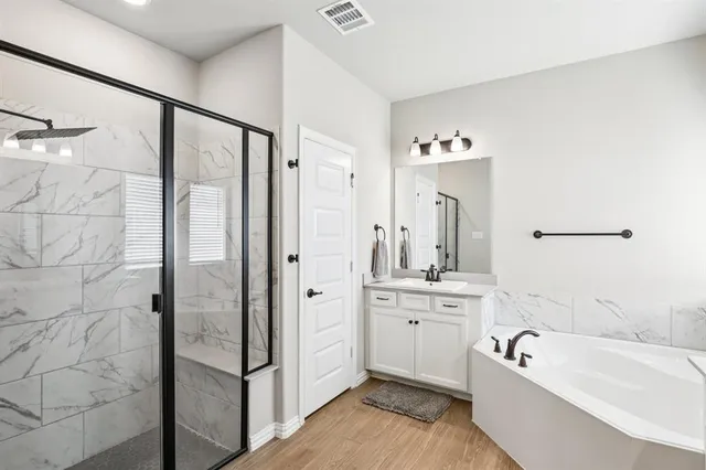 a bathroom with a tub a sink and mirror