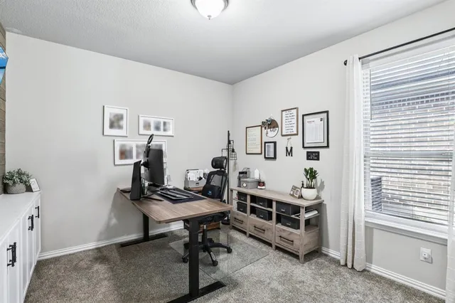 a view of a workspace with furniture and a window