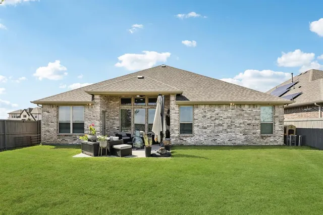 a view of a patio with table and chairs under an umbrella