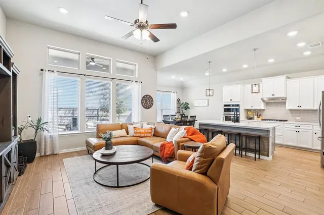 a living room with furniture kitchen view and a large window
