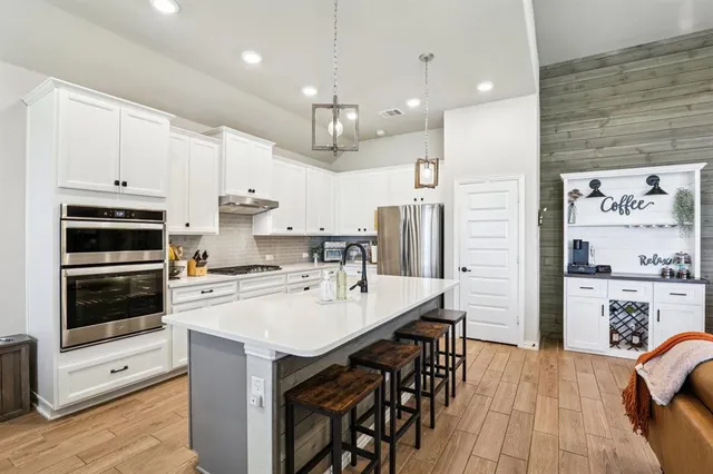 a kitchen with white cabinets and stainless steel appliances