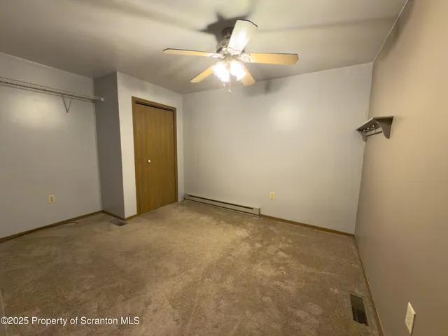 an empty room with a ceiling fan and a window
