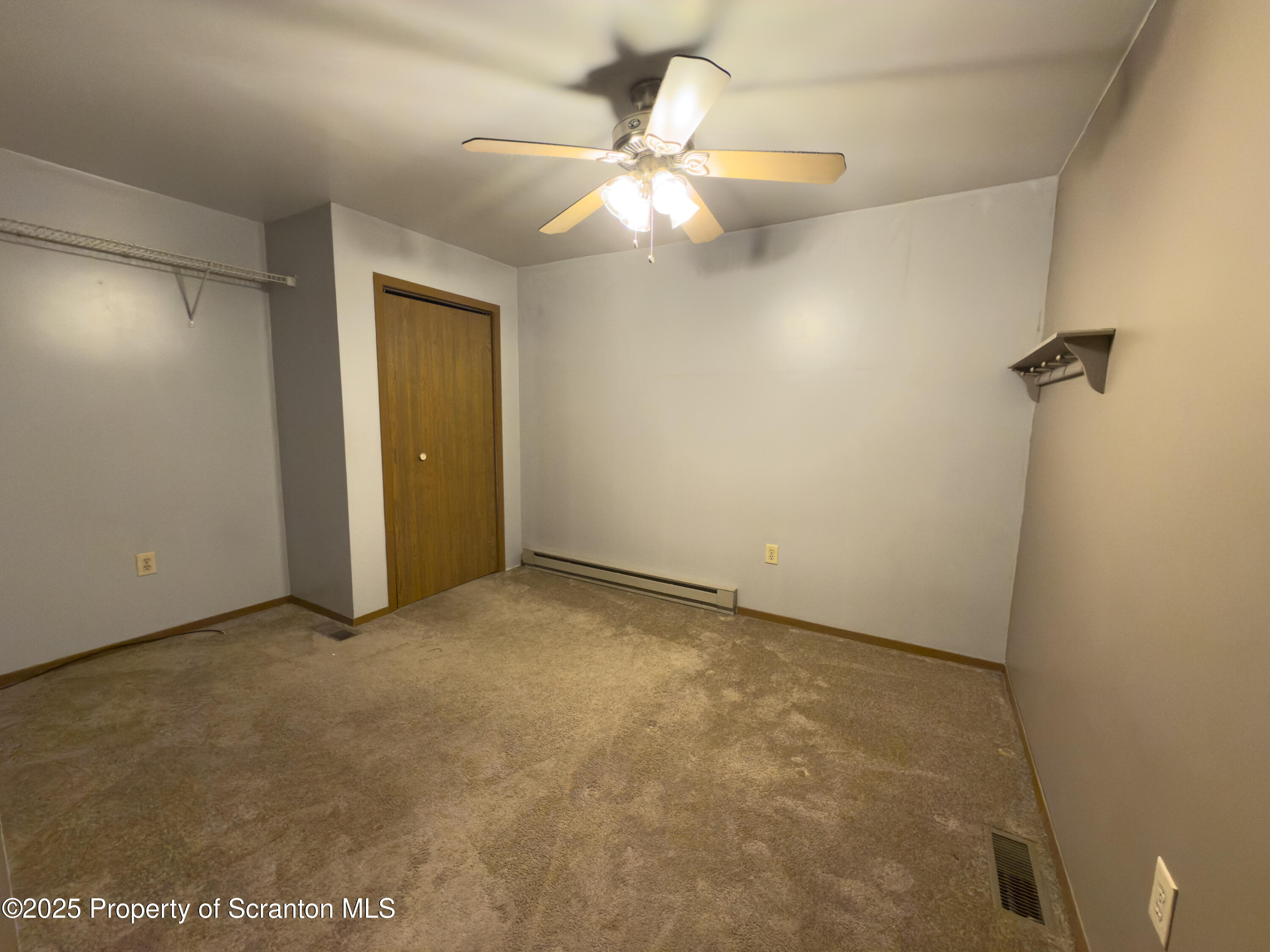 526 Langan Road, Unit G Pittston, PA 18640 - Photo 6 of 8 an empty room with a ceiling fan and a window