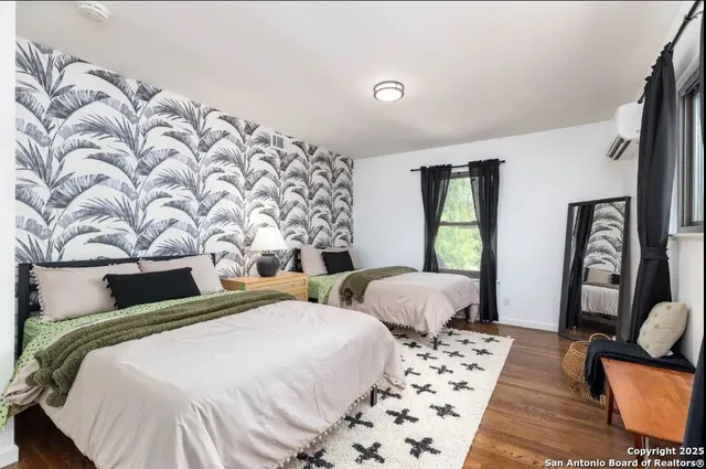 a bedroom with two beds and a large mirror with rug