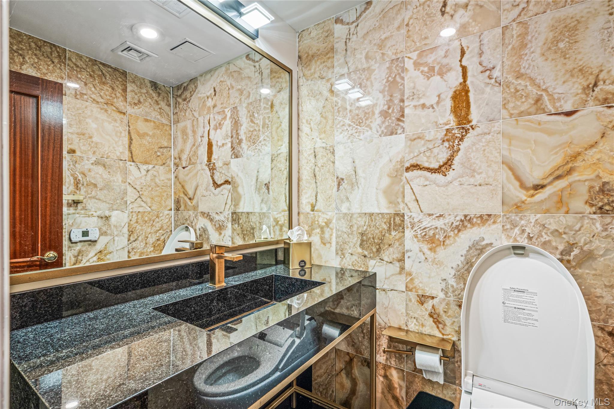 171 Great Neck Road, Unit 4R Great Neck, NY 11021 - Photo 16 of 27 a bathroom with a granite countertop sink a mirror and a shower