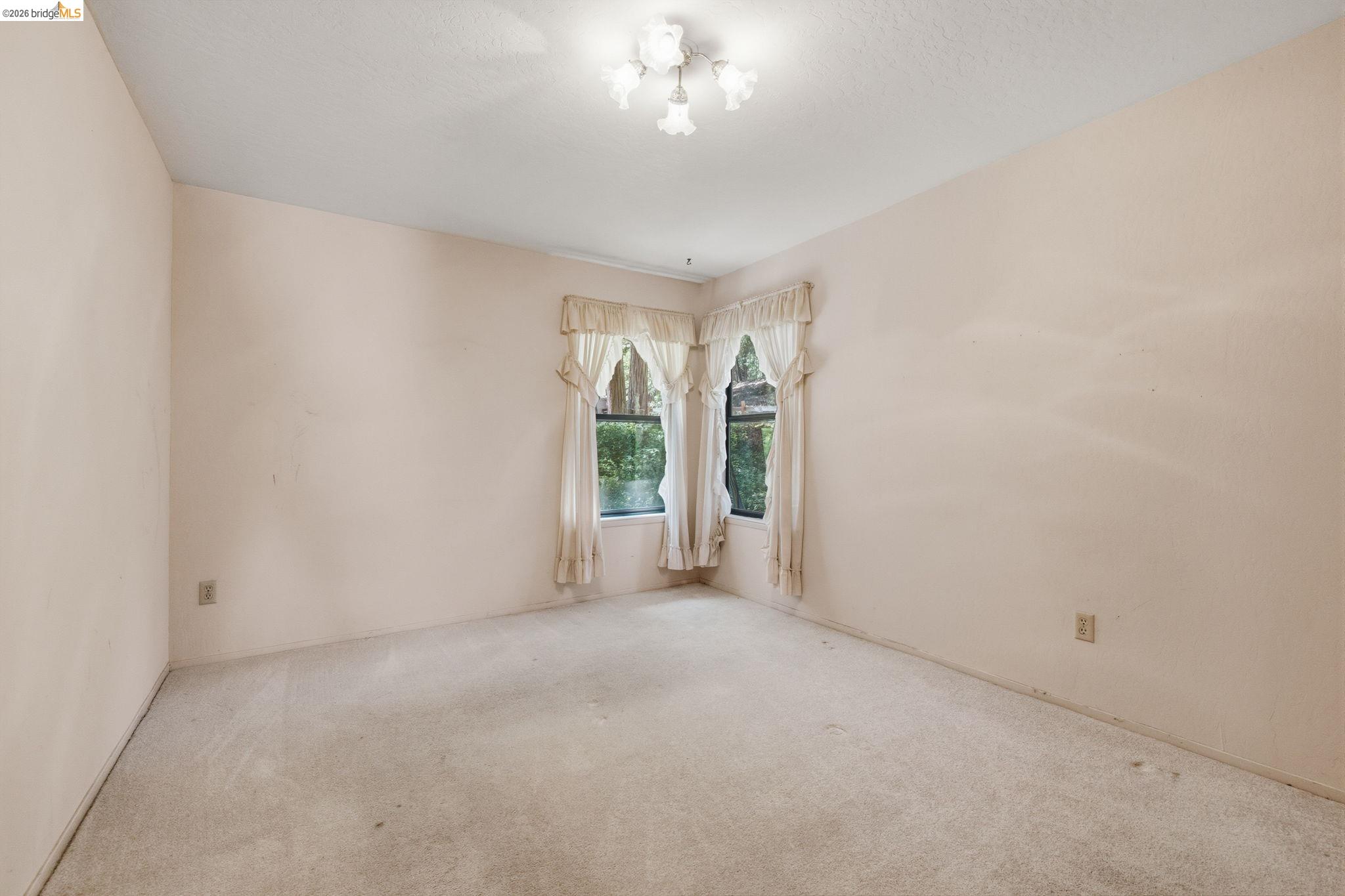 22401 South Fork Road Sonora, CA 95370 - Photo 21 of 34 Carpeted interior room featuring two windows and a ceiling-mounted light fixture