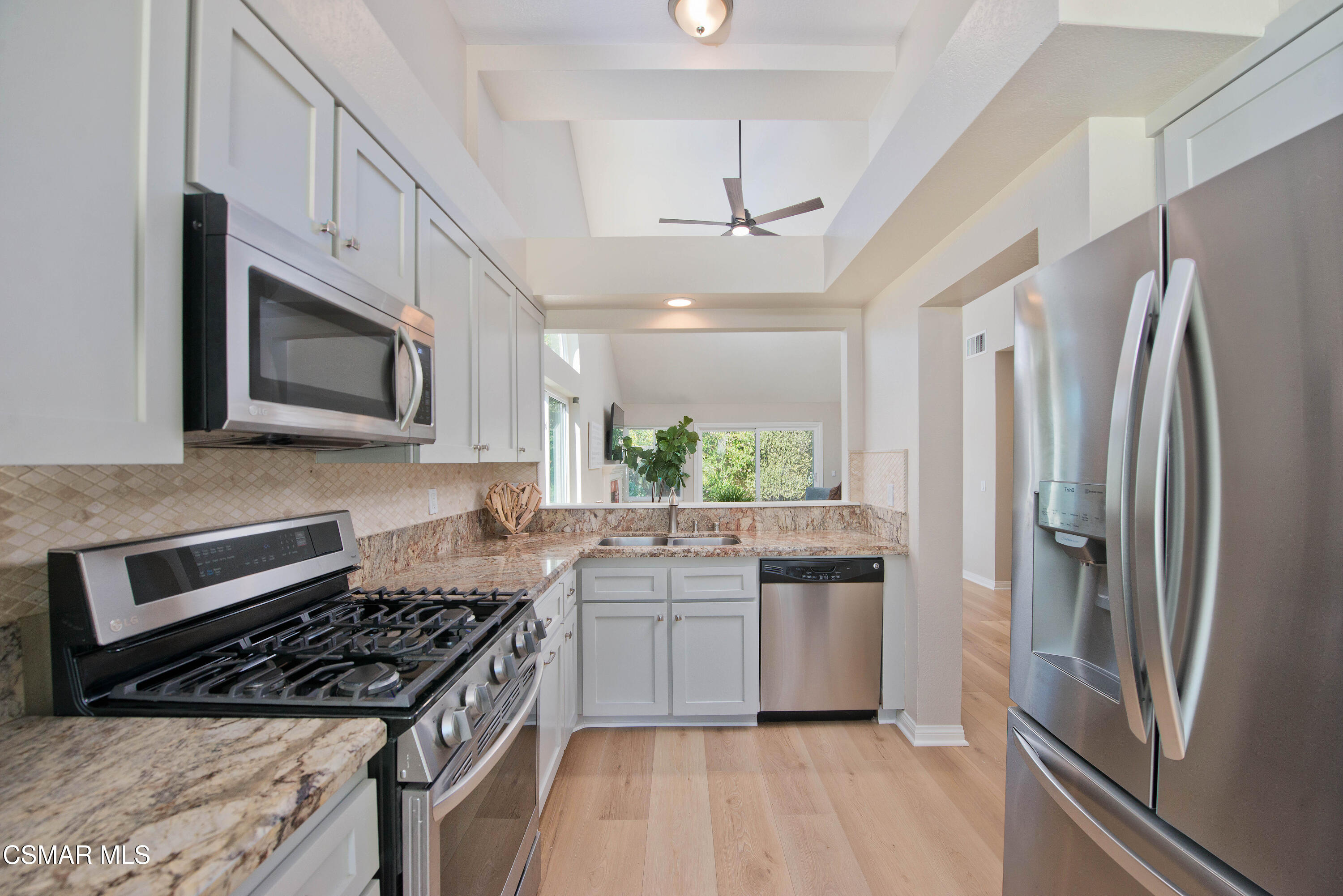 65 Iron Ridge Lane Simi Valley, CA 93065 - Photo 14 of 33 a kitchen with stainless steel appliances granite countertop a refrigerator a sink a stove a microwave and island