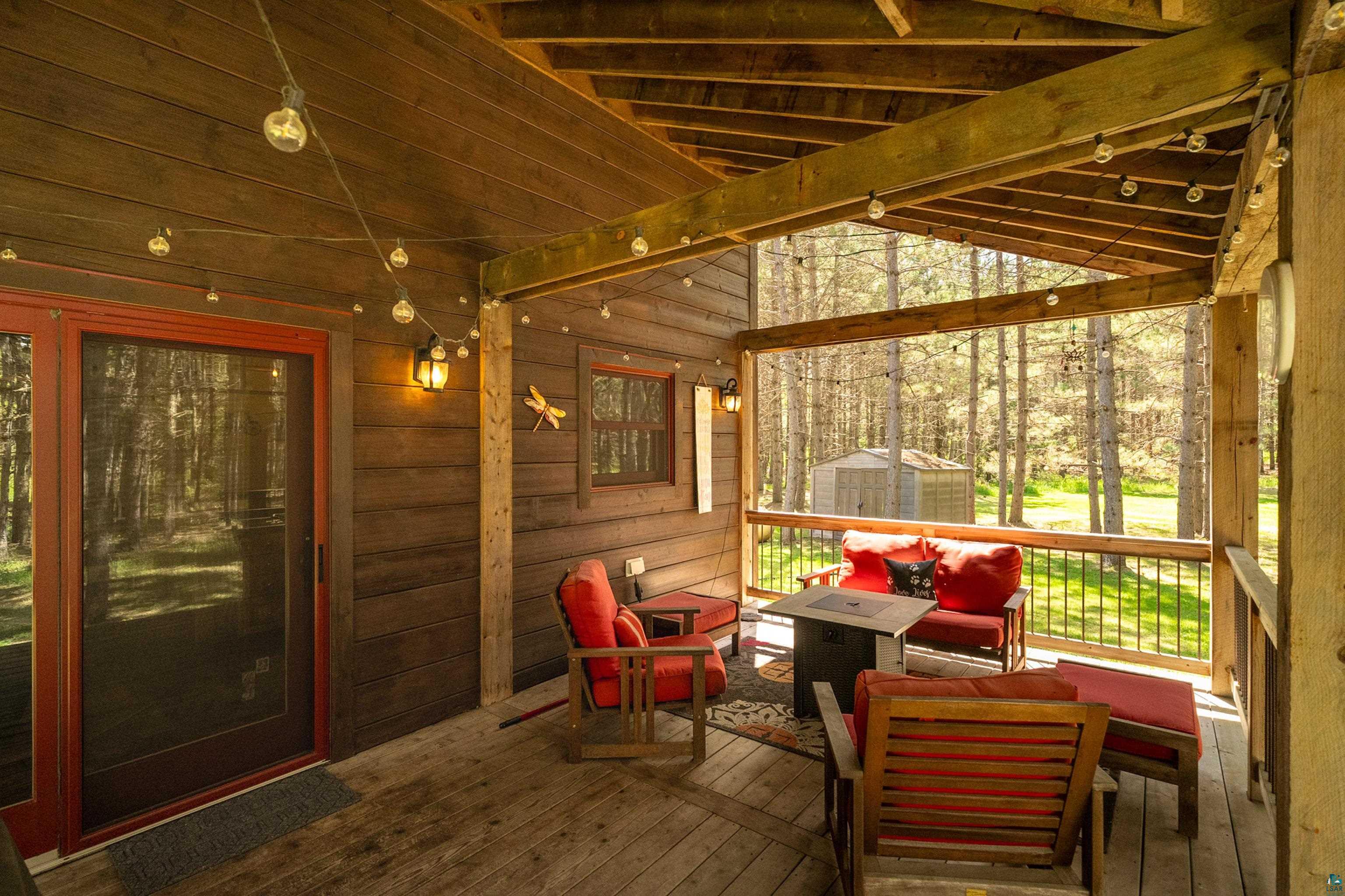 75 East Stark Road Esko, MN 55733 - Photo 63 of 87 Covered outdoor deck featuring exposed wood beams, string lighting, and wood-finish flooring