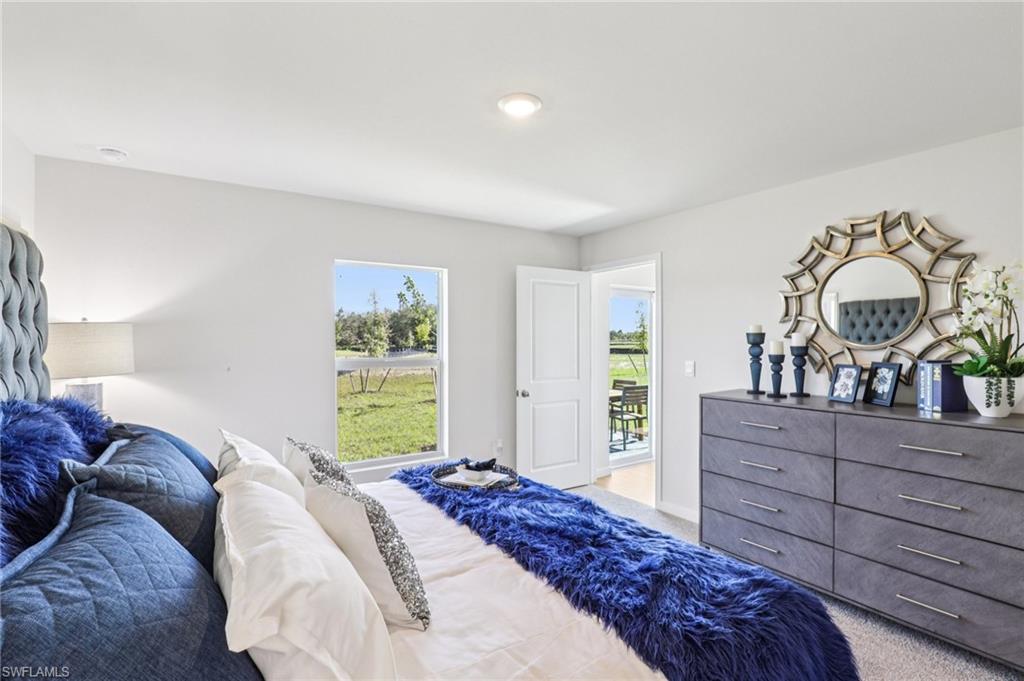 8052 Cedar Ky Way Lehigh Acres, FL 33971 - Photo 24 of 45 Model home. Bedroom featuring light colored carpet and multiple windows
