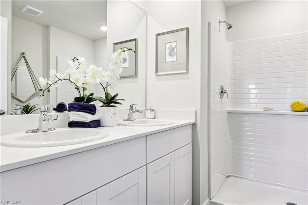 8052 Cedar Ky Way Lehigh Acres, FL 33971 - Photo 25 of 45 Model home. Bathroom featuring double vanity and a stall shower