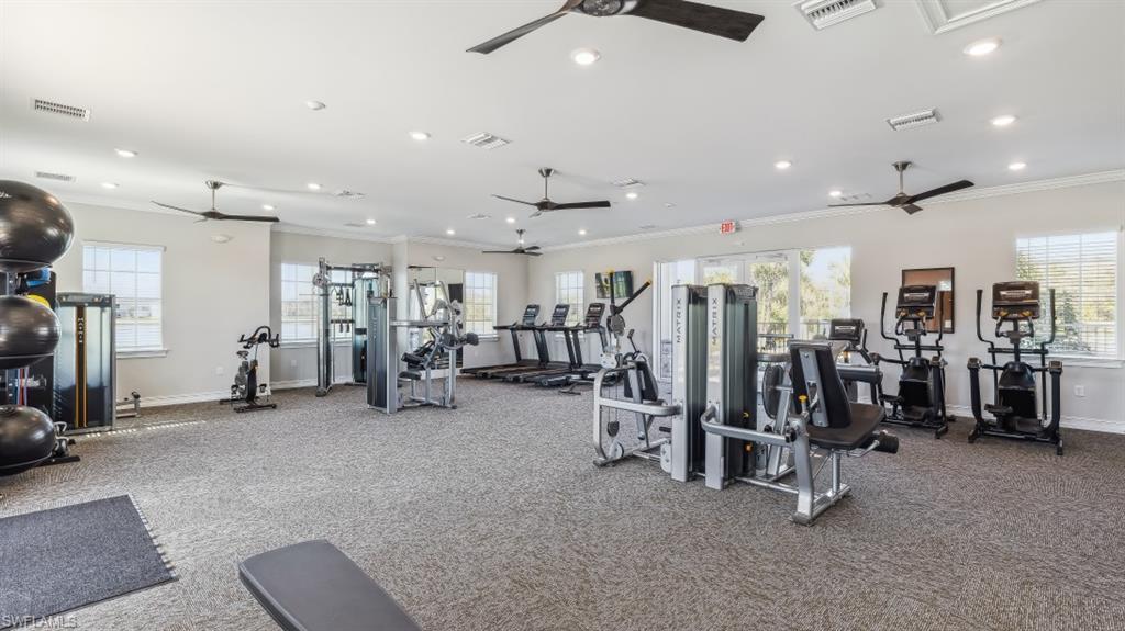 8052 Cedar Ky Way Lehigh Acres, FL 33971 - Photo 29 of 45 Spacious fitness center featuring various exercise machines, ceiling fans, and multiple windows providing natural light