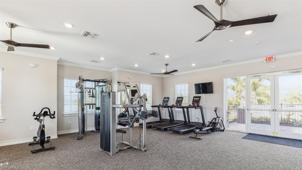 8052 Cedar Ky Way Lehigh Acres, FL 33971 - Photo 30 of 45 The property features a well-appointed fitness center with exercise equipment, ceiling fans, and large glass doors providing natural light