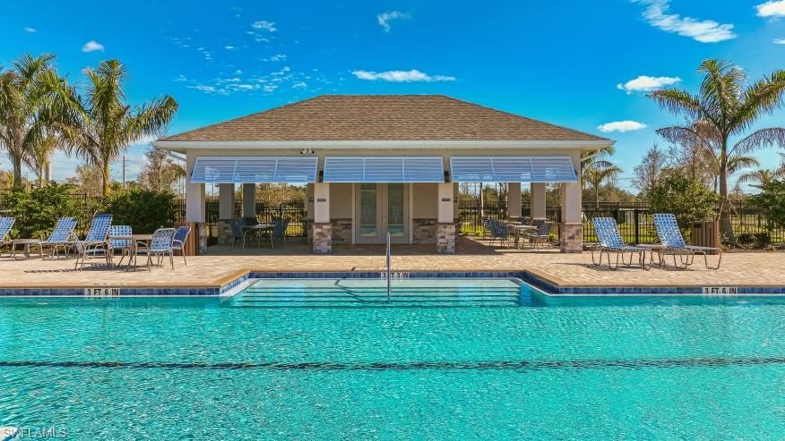 8052 Cedar Ky Way Lehigh Acres, FL 33971 - Photo 39 of 45 The property features a large swimming pool with integrated steps, surrounded by a paved deck with loungers