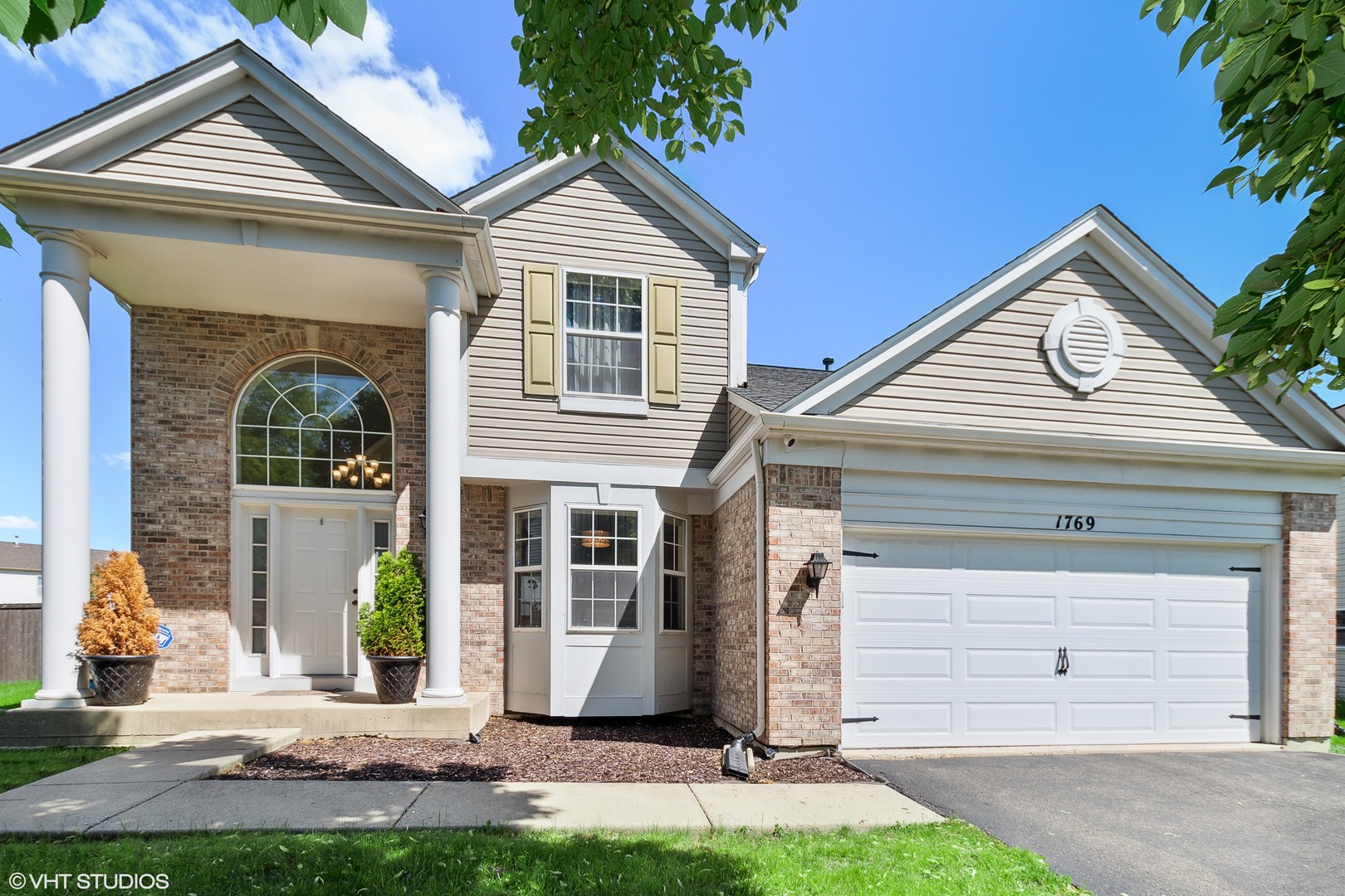 a front view of a house with a yard and garage