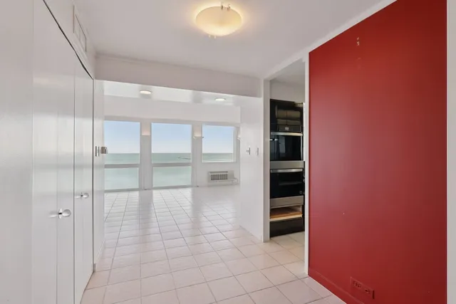 a view of an empty room with cabinet and entryway