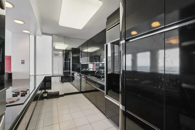 a kitchen with granite countertop a refrigerator and a stove top oven