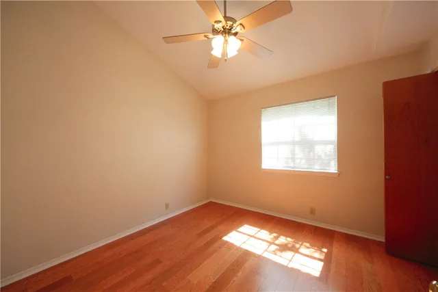 an empty room with a window and wooden floor