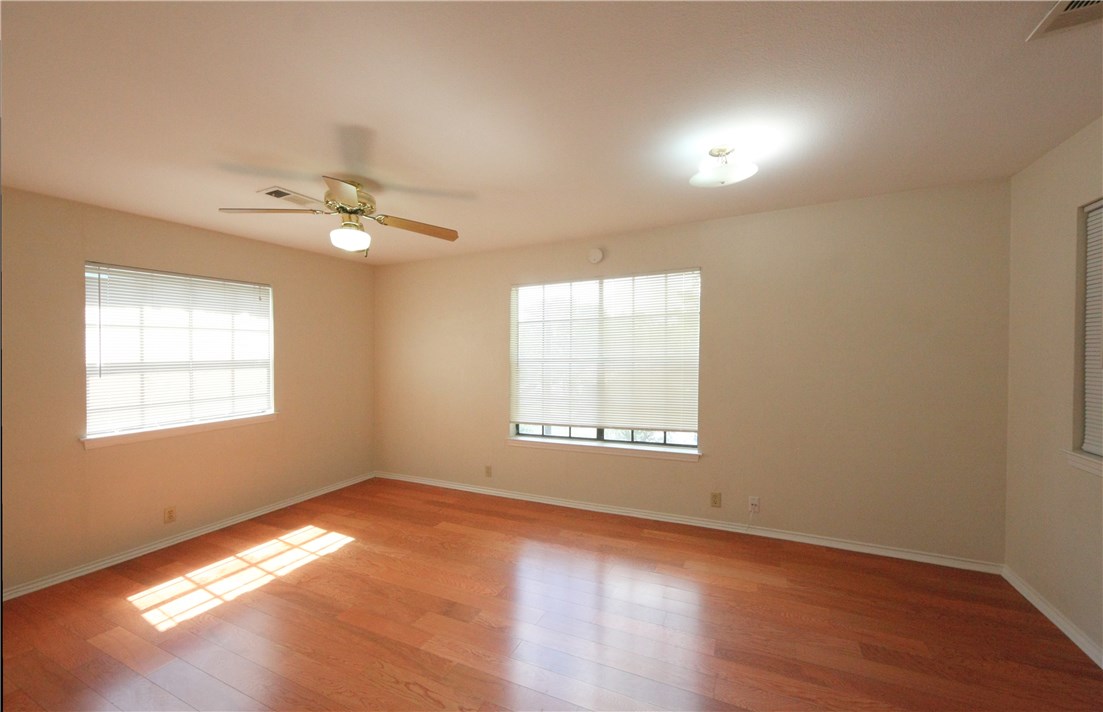 1903 East 20th Street, Unit 302 Austin, TX 78722 - Photo 9 of 11 an empty room with wooden floor chandelier fan and windows