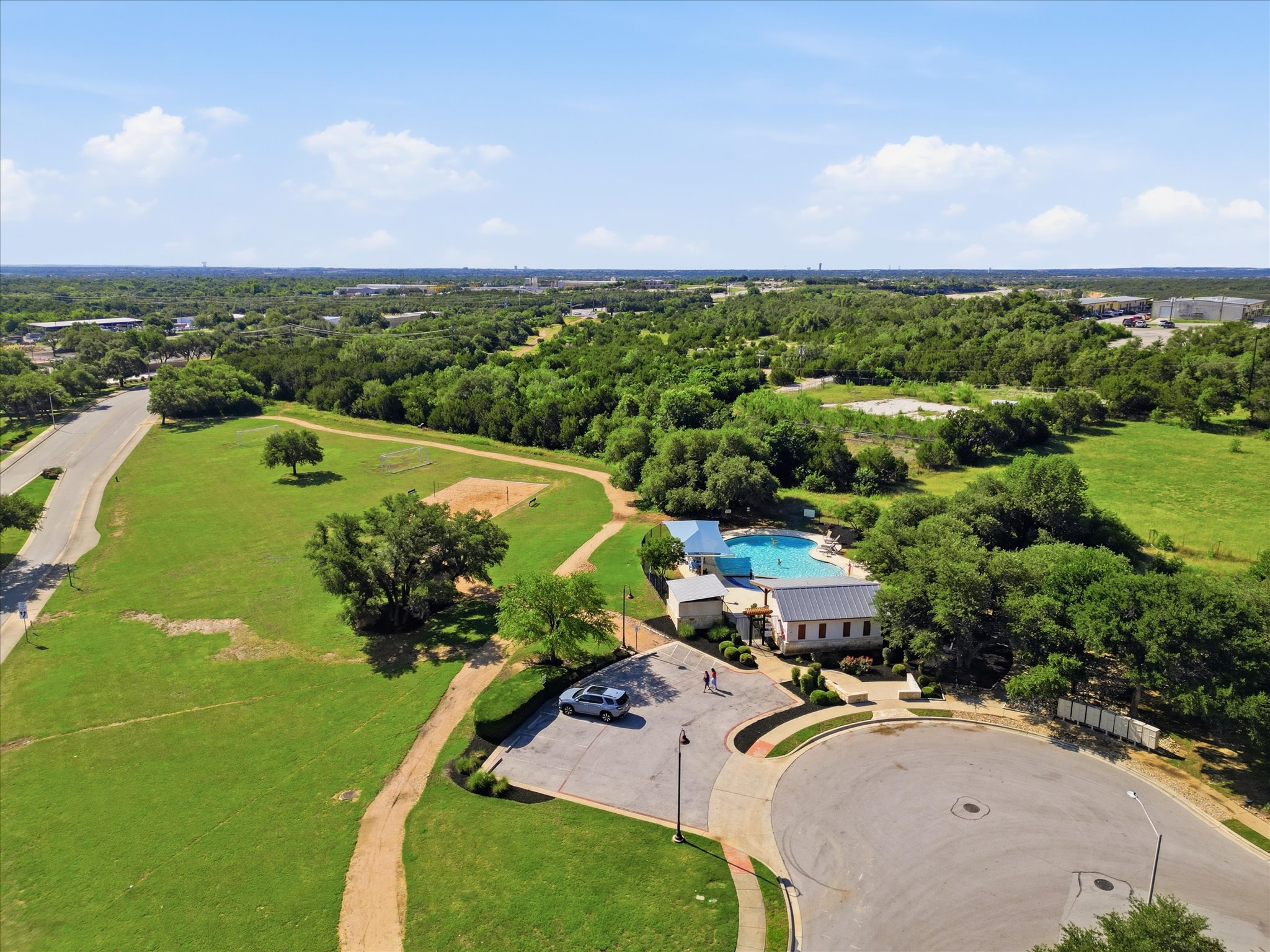 1511 Rimstone Drive Cedar Park, TX 78613 - Photo 36 of 39 An aerial perspective reveals a community pool and recreational grounds nestled within a verdant landscape.