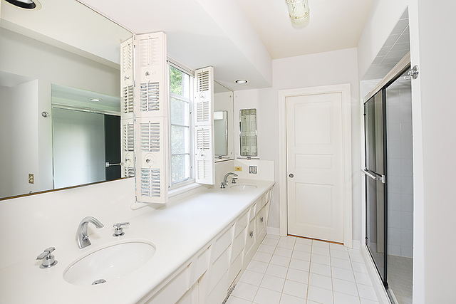 115 Woodley Road Winnetka, IL 60093 - Photo 33 of 41 a spacious bathroom with a double vanity sink a mirror and a shower
