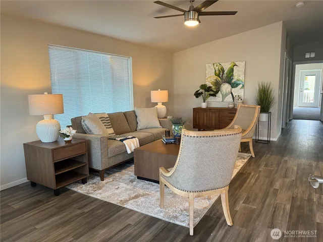 a living room with furniture a window and a potted plant